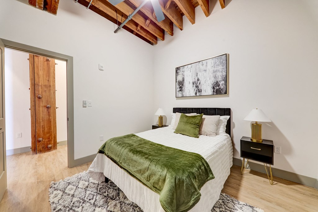 a bedroom with a bed and a green blanket at Greeley Lofts, St. Louis