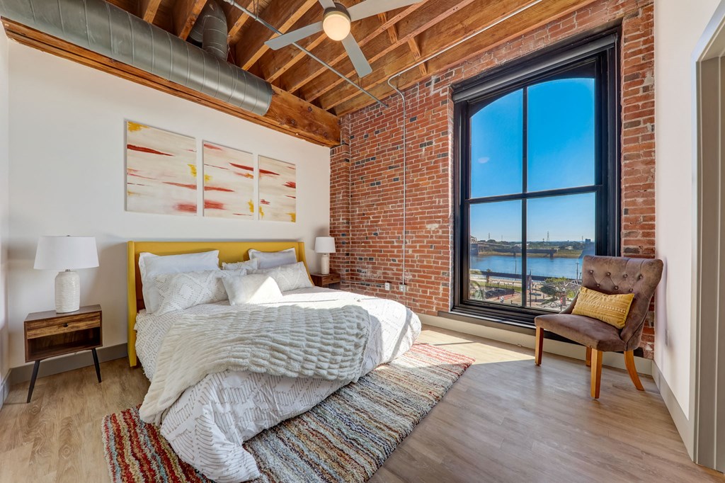 a bedroom with a bed and a large window at Greeley Lofts, St. Louis, MO