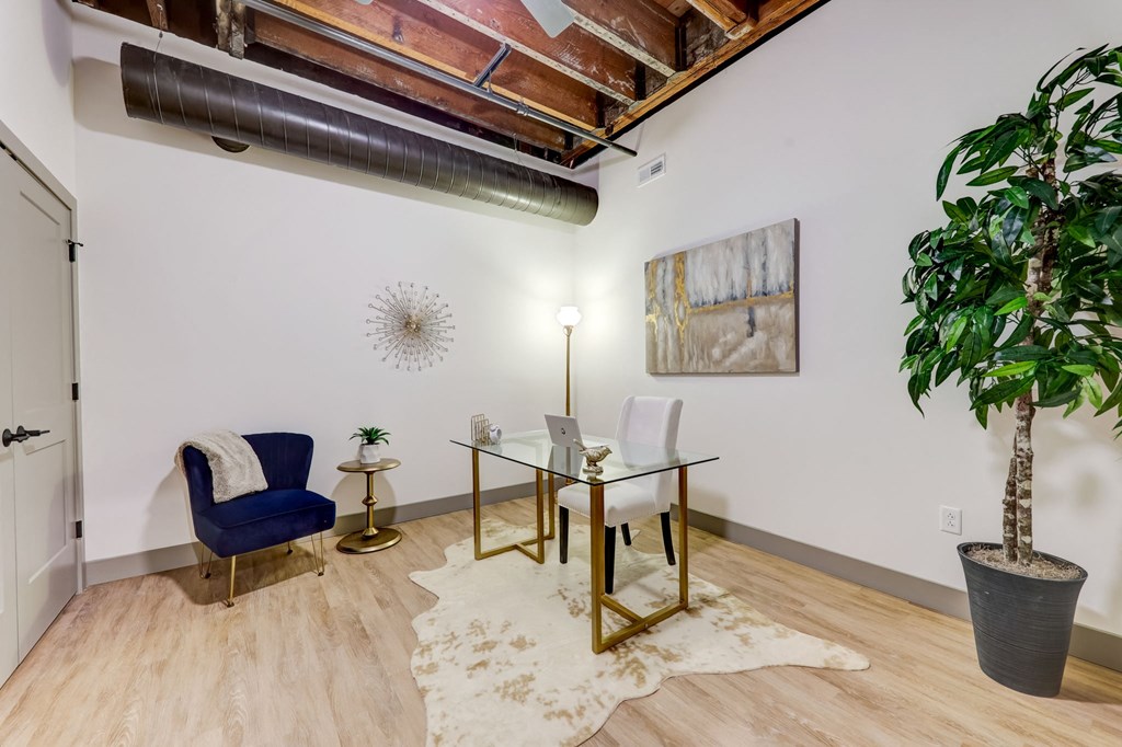 a conference room with a glass desk and a chair and a plant at Greeley Lofts, St. Louis, Missouri