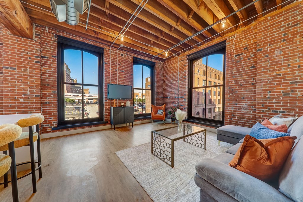 a living room with a couch and a large window at Greeley Lofts, Missouri