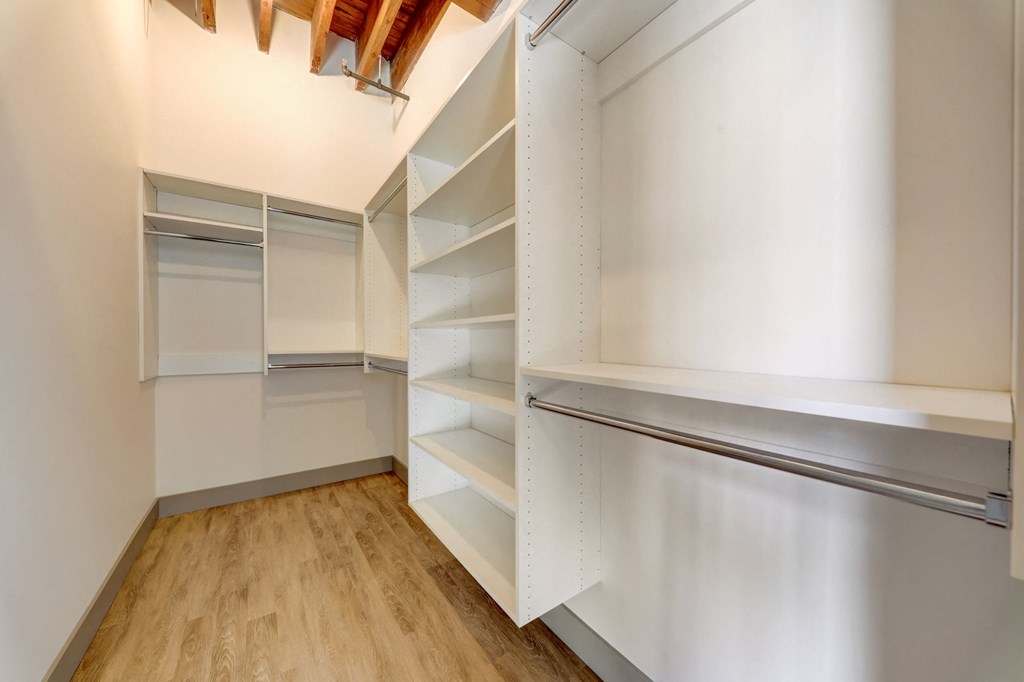 a walk in closet with shelves and a refrigerator at Greeley Lofts, St. Louis, 63102
