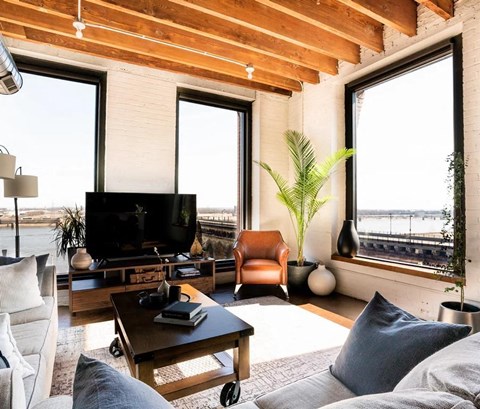 a living room with a couch and a tv     and a window
