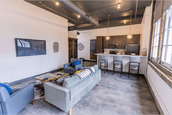 a living room with a couch and a kitchen with a bar