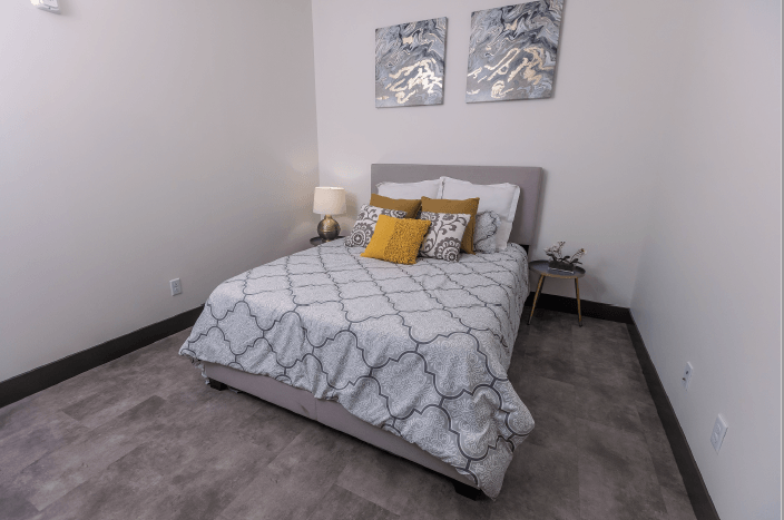 a bedroom with a bed and two paintings on the wall