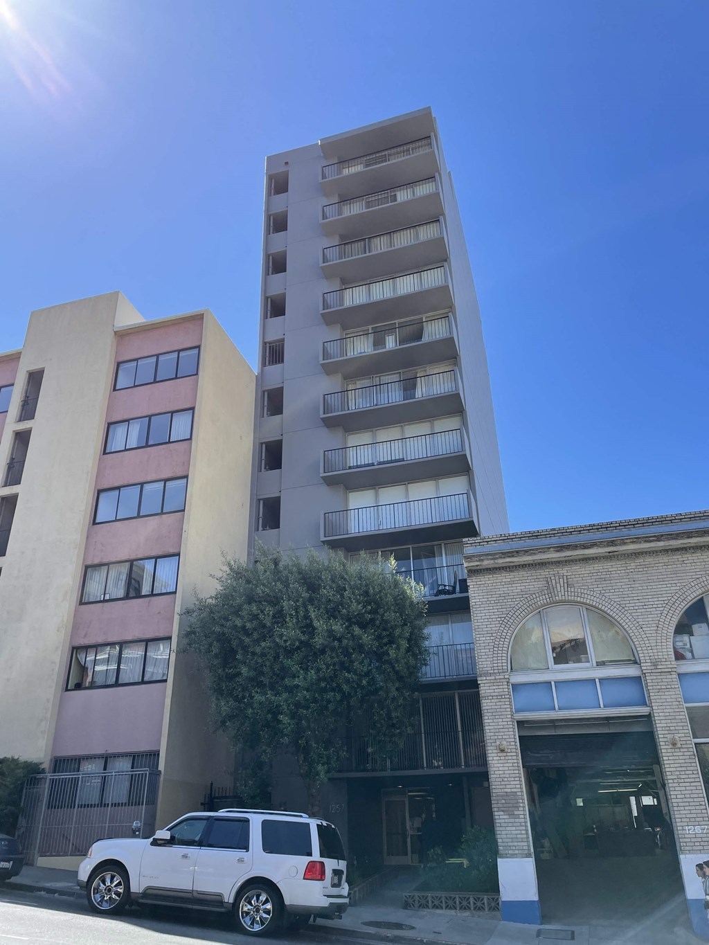 a white van parked in front of a tall building