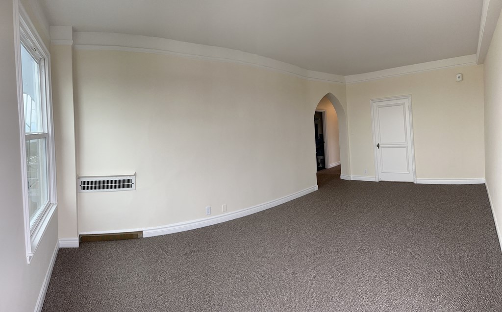 an empty living room with white walls and a carpet