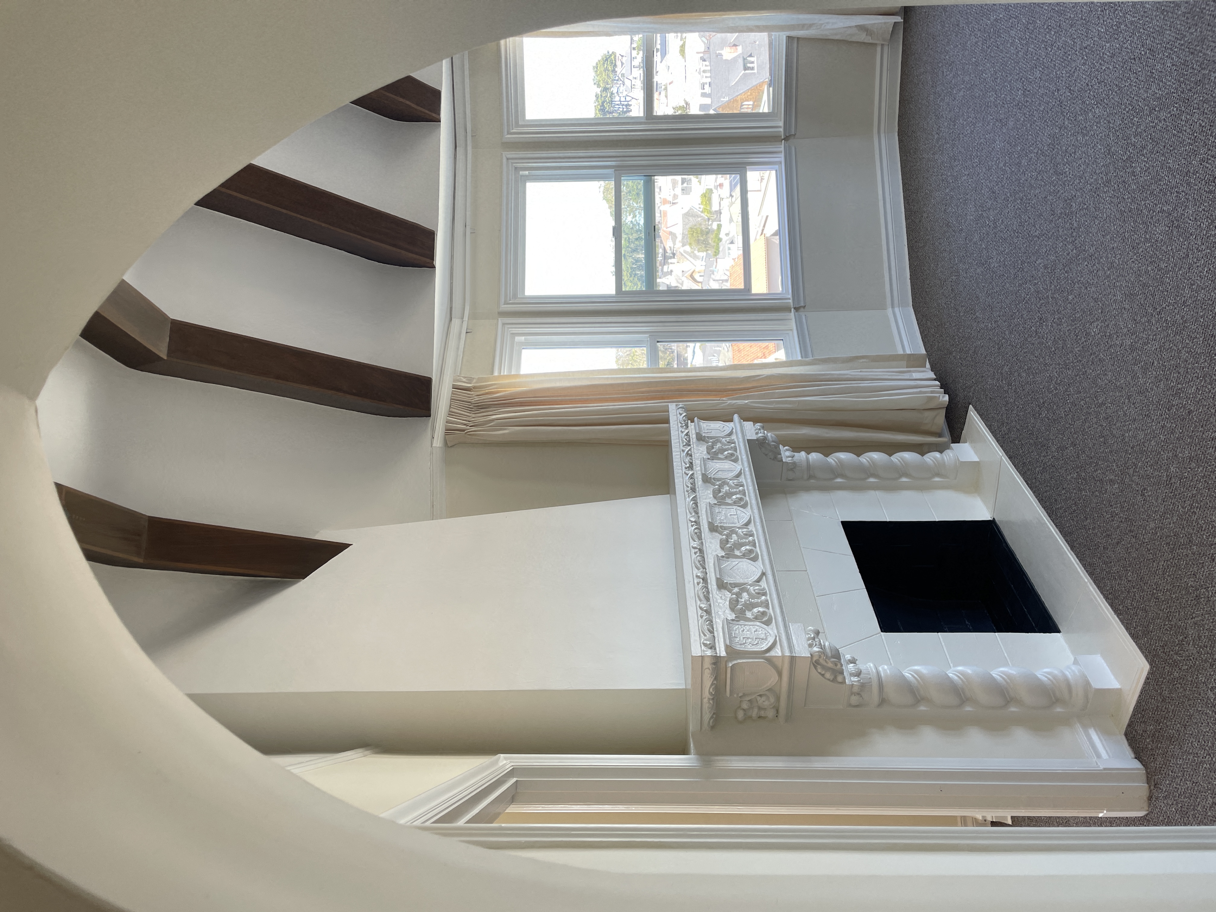 a view of a stairwell with a white staircase and a window