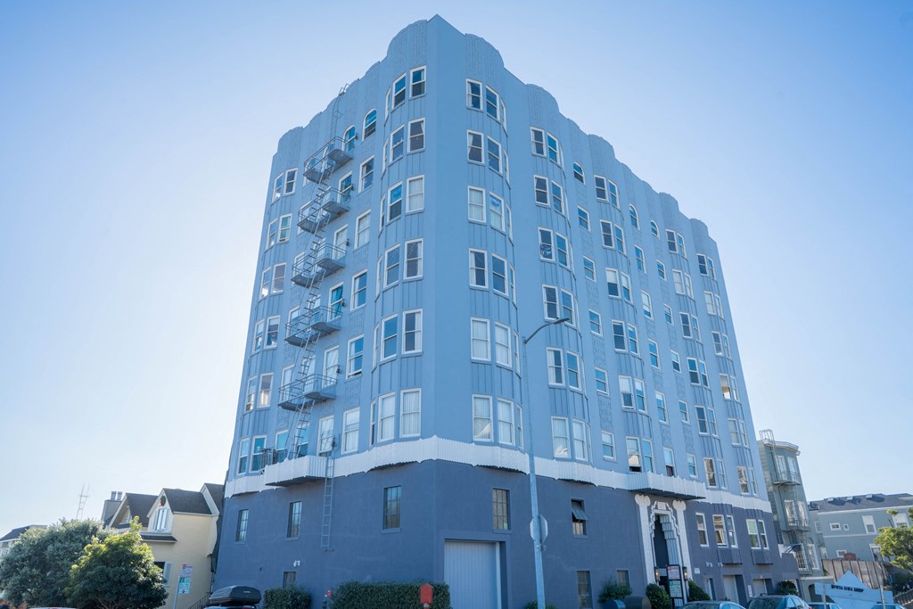 a blue building on a city street with a blue sky