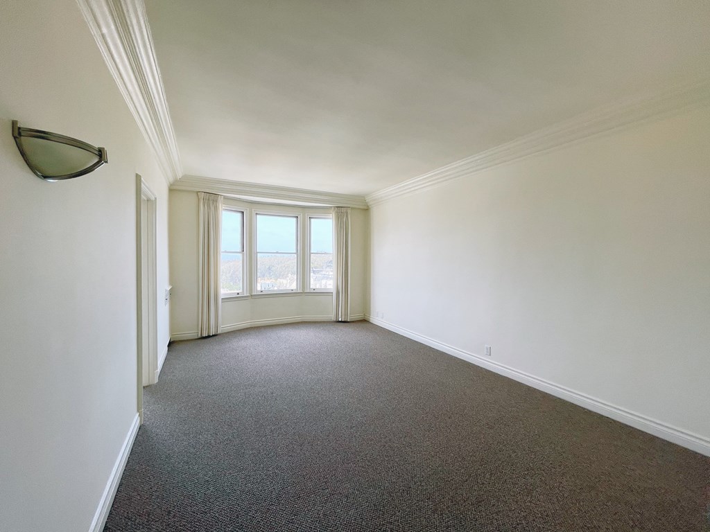 an empty living room with white walls and a window