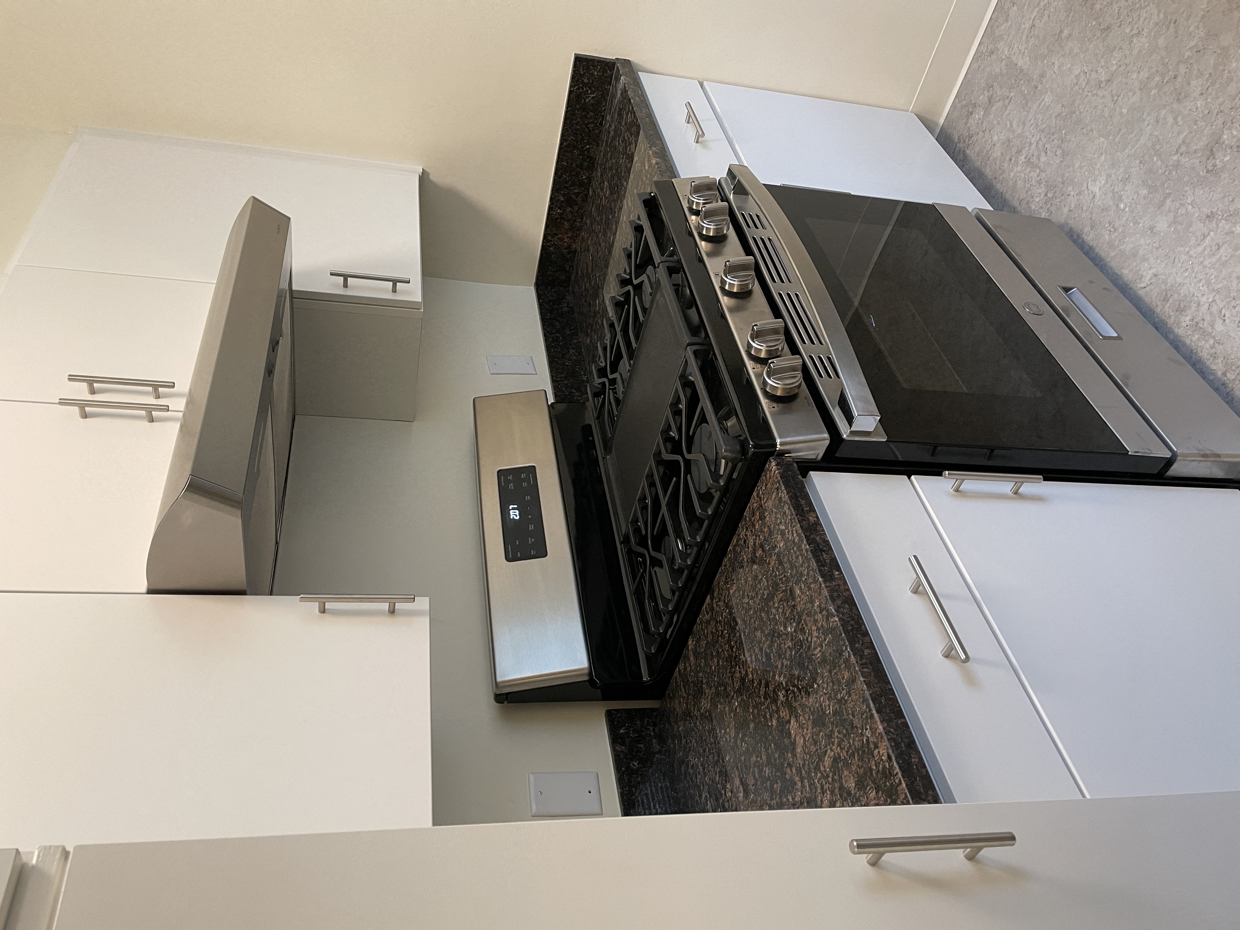 an island in a kitchen with a stove and a refrigerator