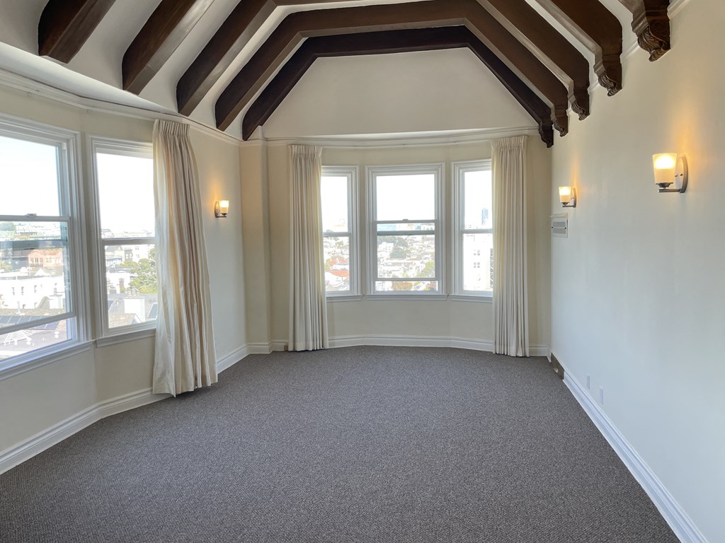 an empty living room with windows and a carpet