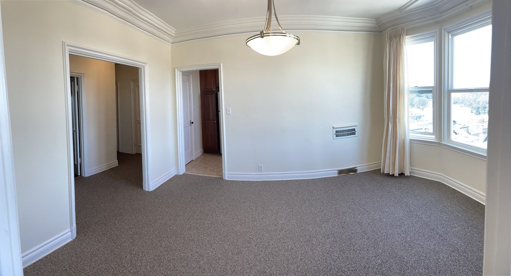 an empty living room with white walls and a carpet