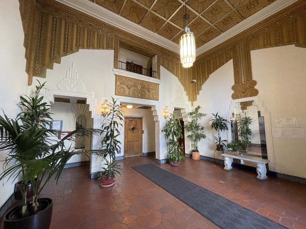 a large lobby with potted plants and a chandelier