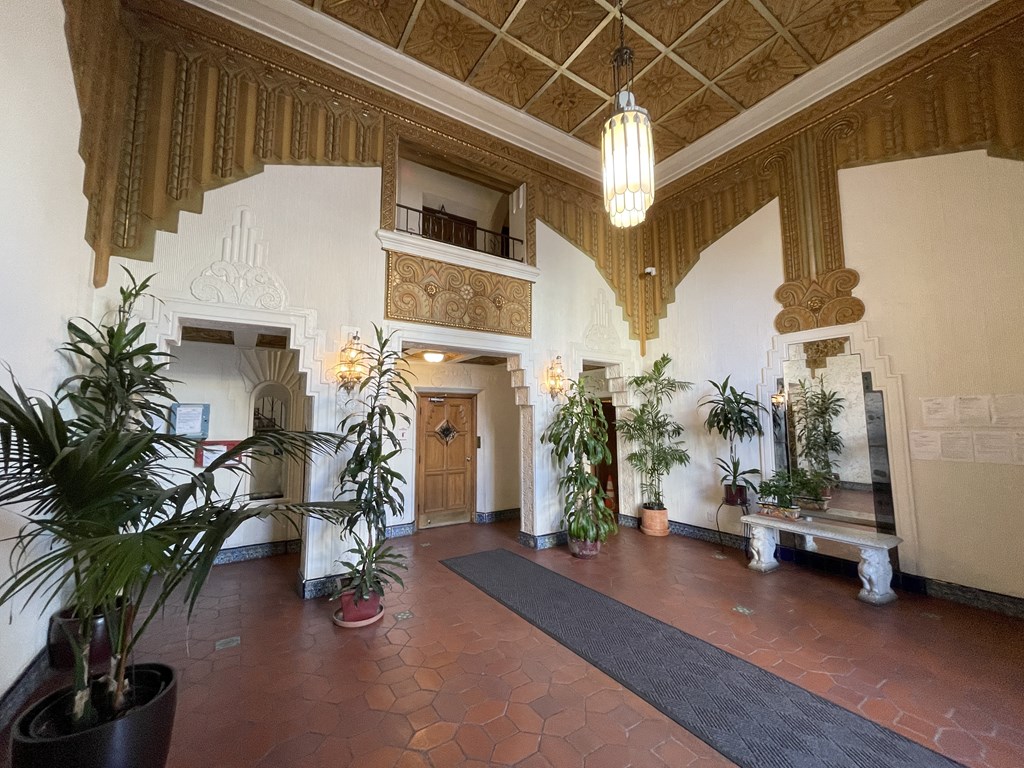 a large lobby with potted plants and a chandelier