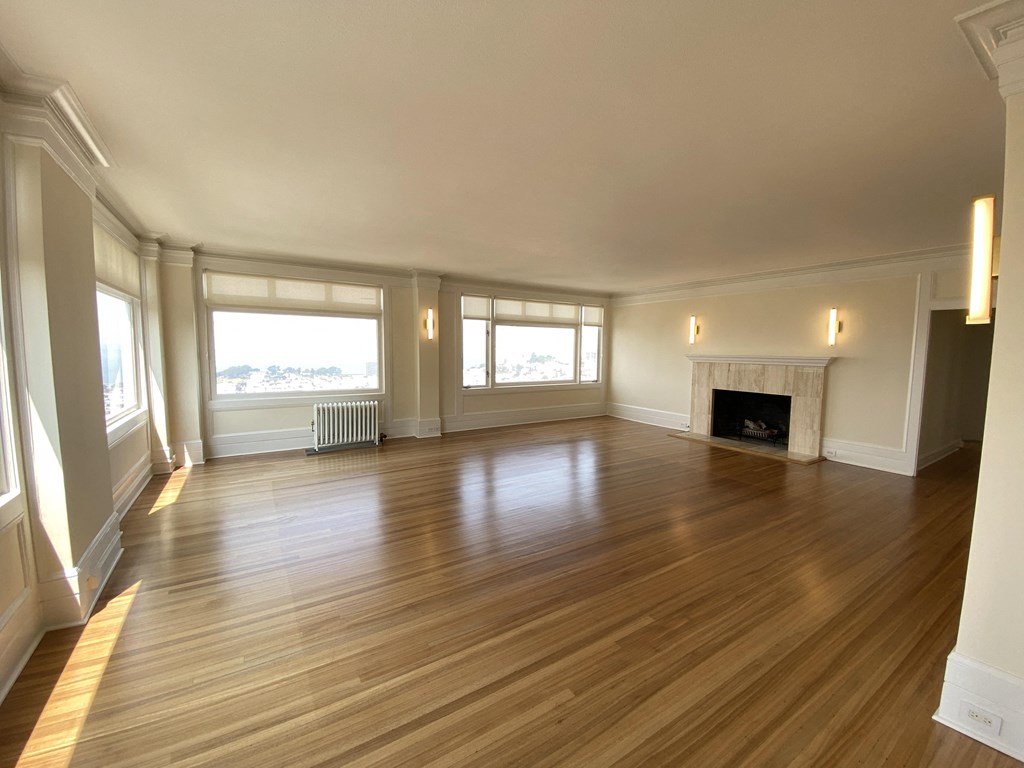 an empty living room with wood floors and a fireplace