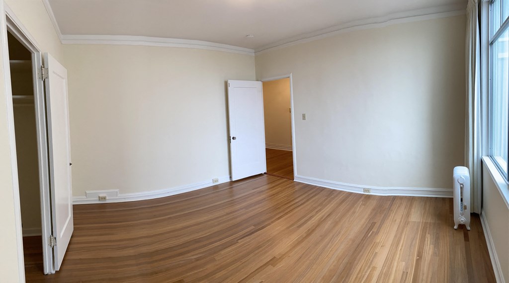 an empty living room with wooden floors and white walls