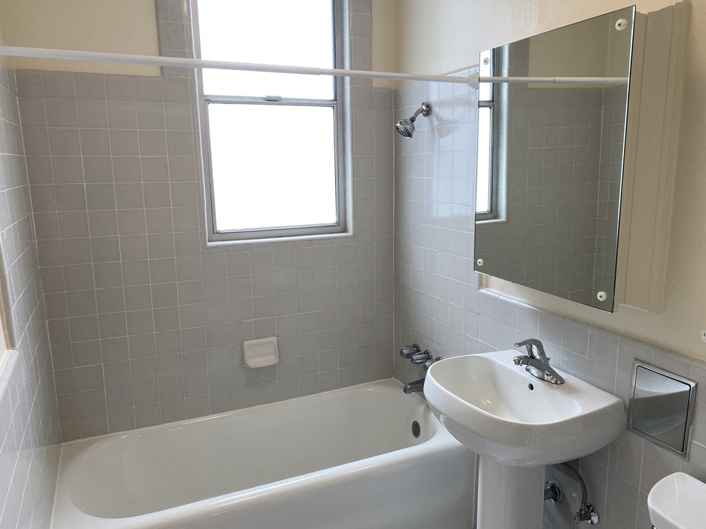 a bathroom with a sink and a bath tub and a window
