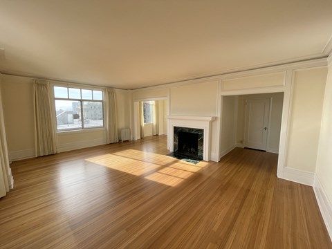 an empty living room with wood floors and a fireplace