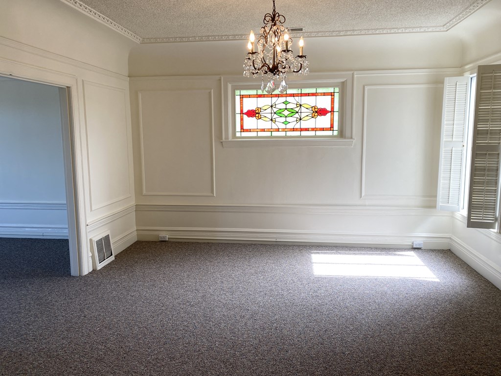 a dining room with a chandelier and a stained glass window