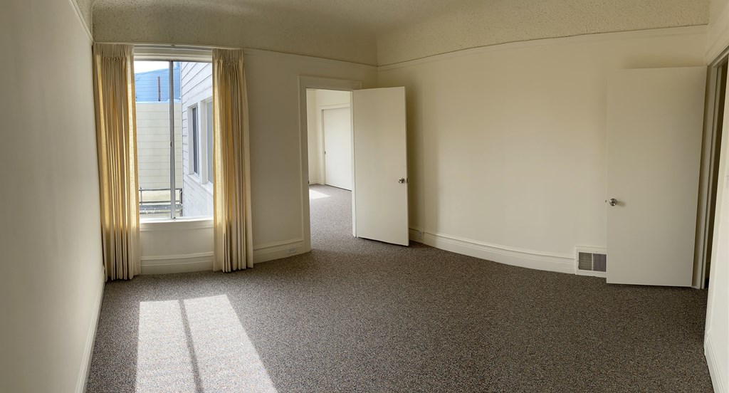 an empty room with a window and a door