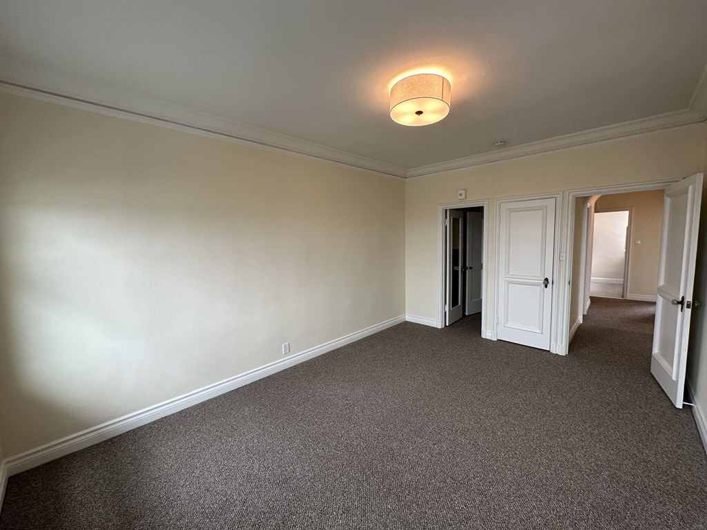 an empty living room with white walls and a carpet
