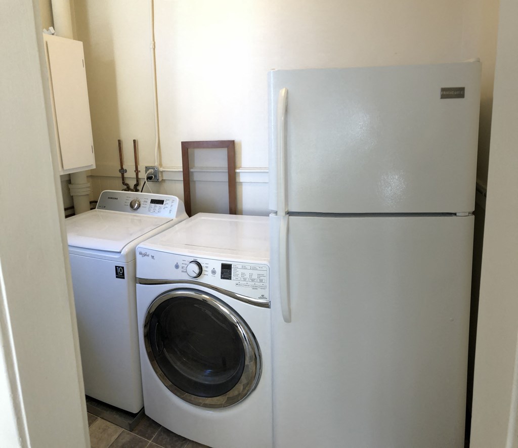 a white washer and dryer in a kitchen next to a refrigerator