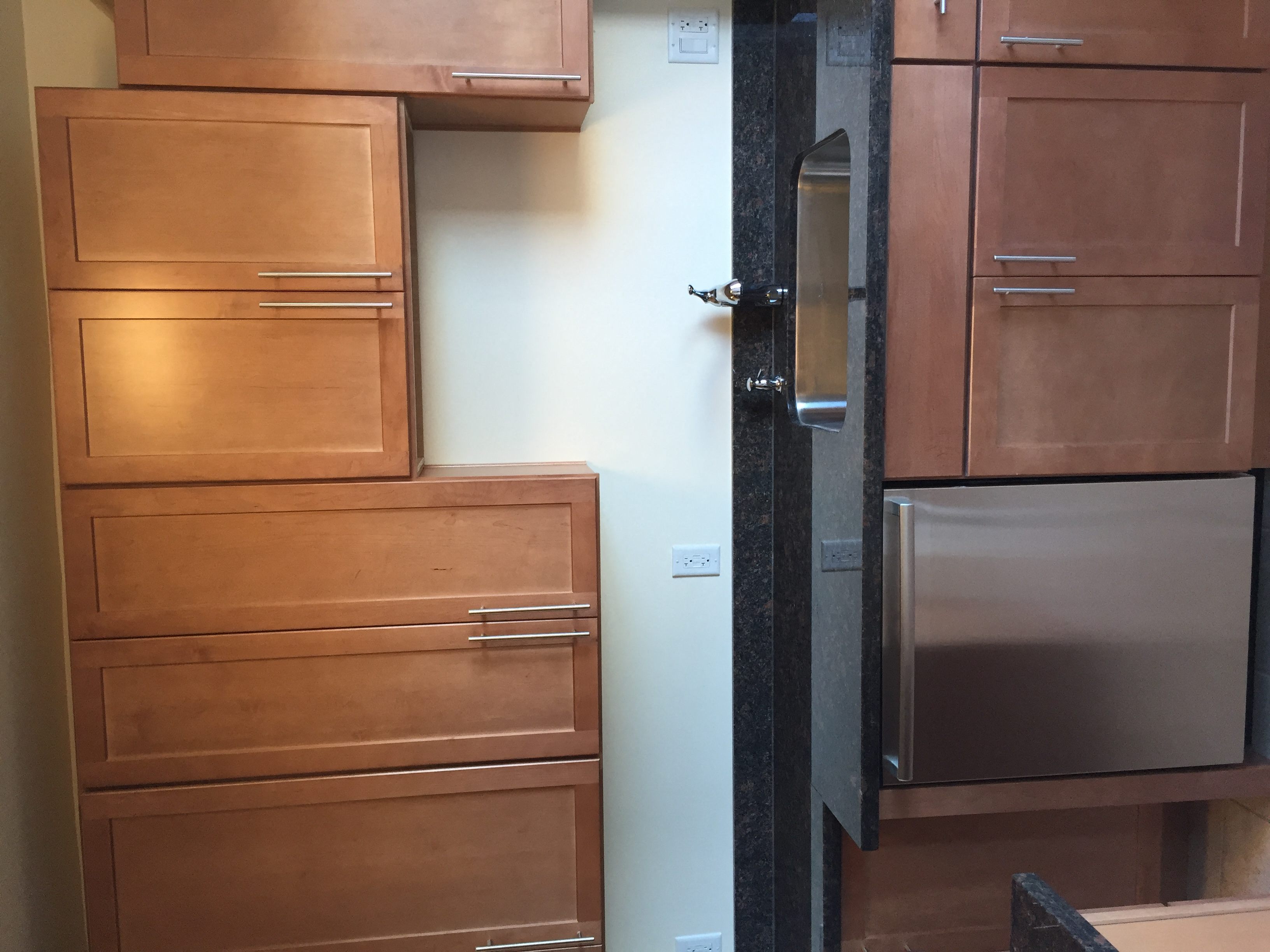 a kitchen with wooden drawers and a refrigerator