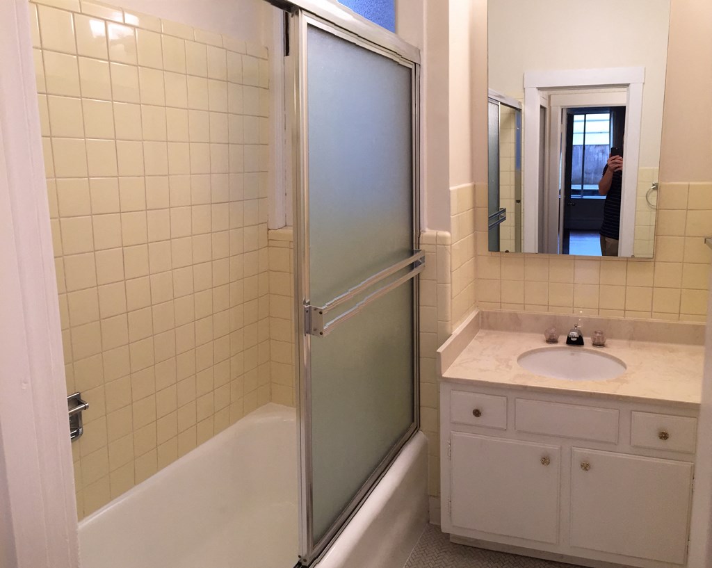 a white bathroom with a shower and a sink