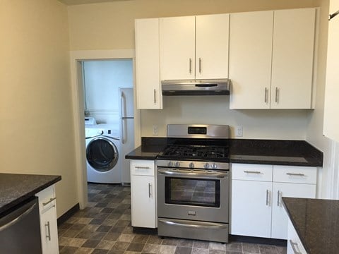 a kitchen with white cabinets and stainless steel appliances