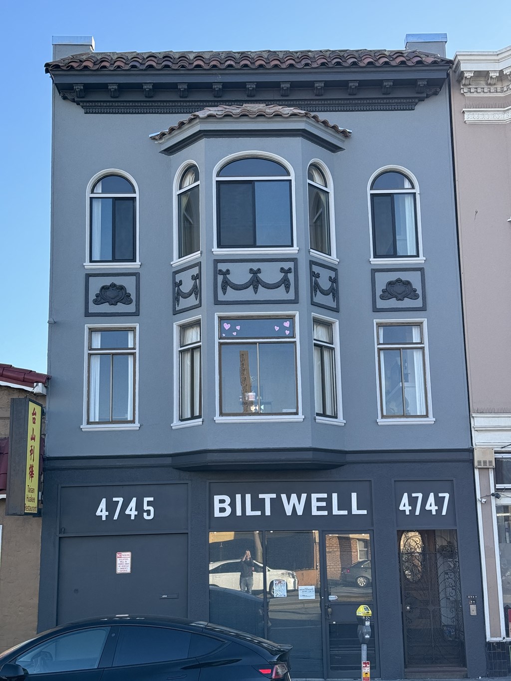 a blue building with a car in front of it