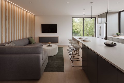 A modern living room with a grey sofa and a television on the wall.