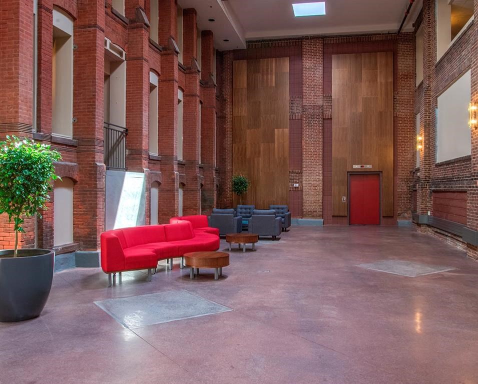 the lobby of a building with a red couch and chairs