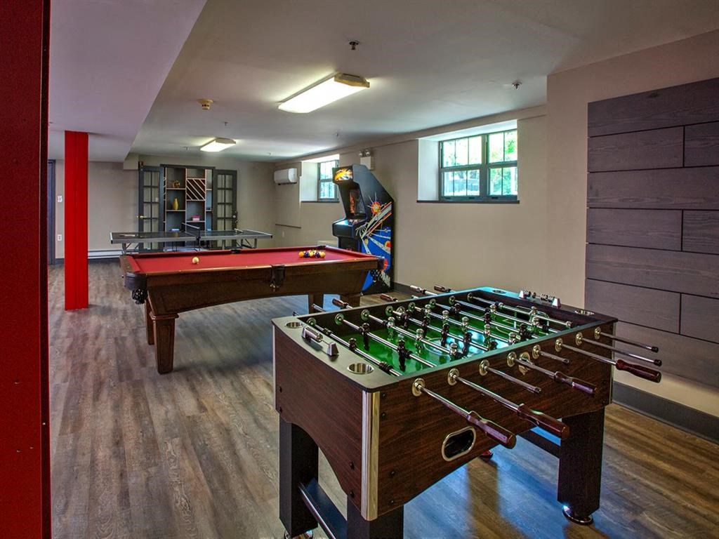a game room with two pool tables and a foosball