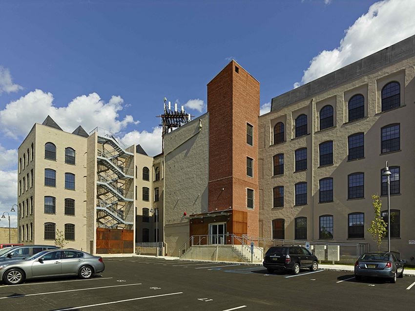 the exterior of a building with cars parked in a parking lot