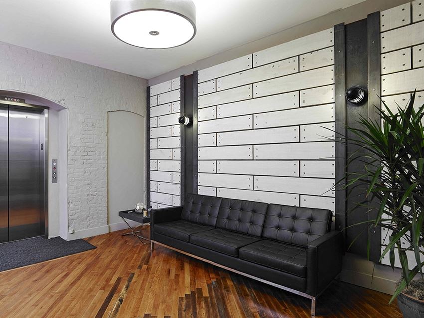 a living room with a leather couch and a wall with white bricks