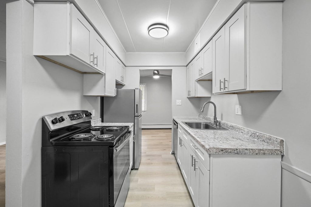 a kitchen with white cabinets and a black stove and refrigerator