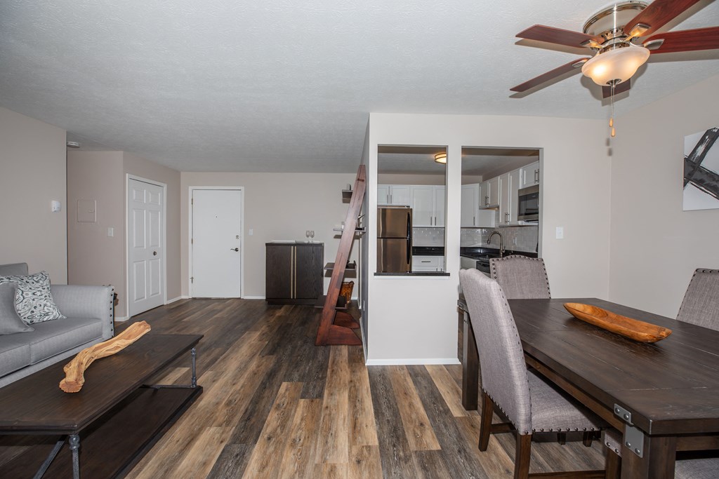 a living room and dining room with hardwood floors and a ceiling fan
