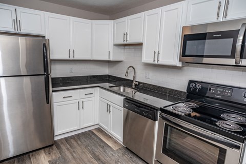 a kitchen with stainless steel appliances and white cabinets