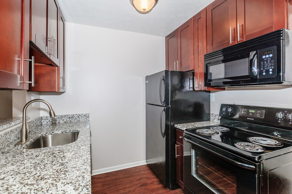 a kitchen with black appliances and granite countertops