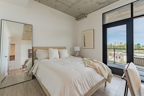 A bedroom with a large bed and a view of the city.