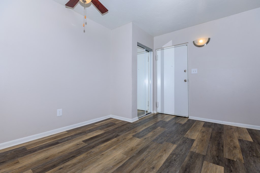 a bedroom with hardwood flooring and a ceiling fan