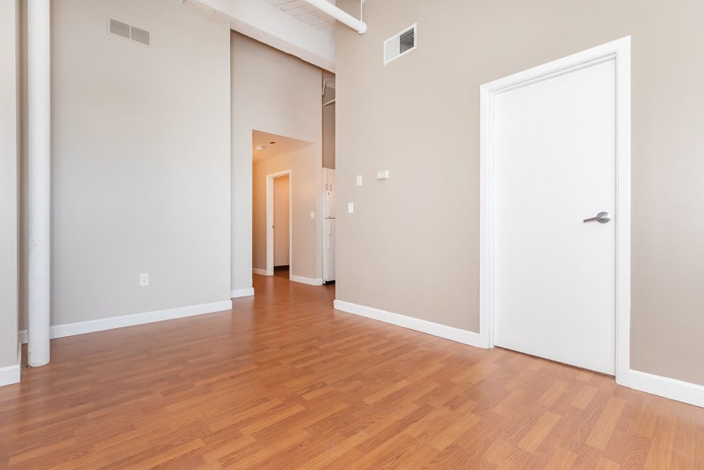 a living room and hallway with wood flooring and a white door