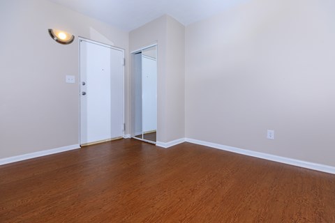 a bedroom with hardwood floors and white walls