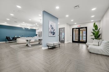 A spacious room with a blue accent wall and a white chair at Park Lamont Townhomes Apartments, Cleveland 44106