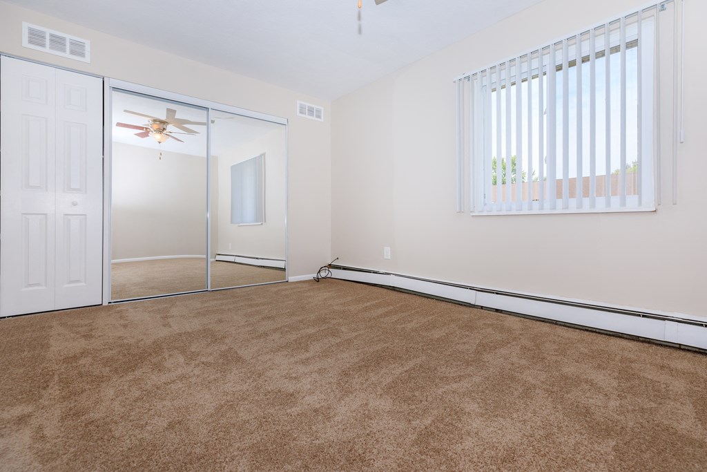 a bedroom with carpeting and a ceiling fan