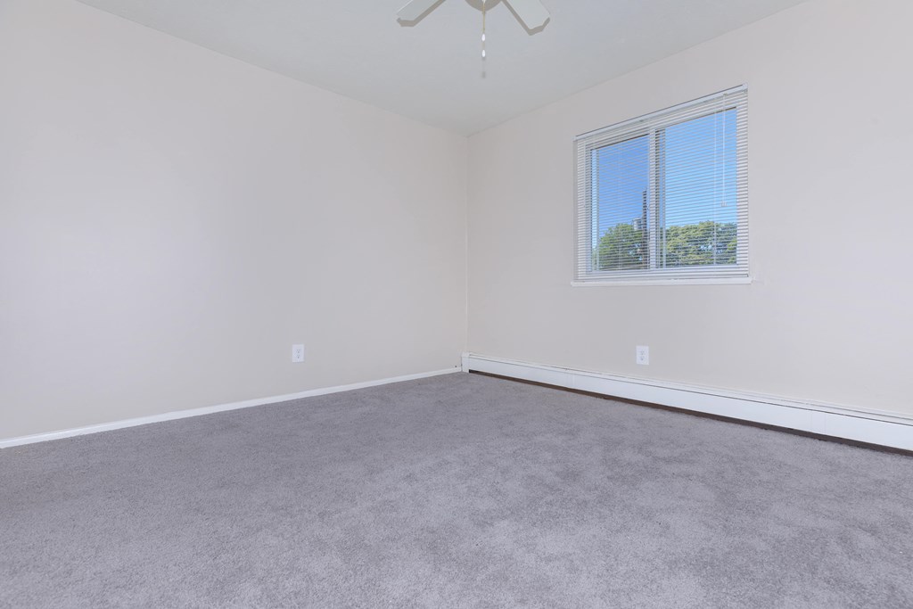 a bedroom with gray carpet and white walls