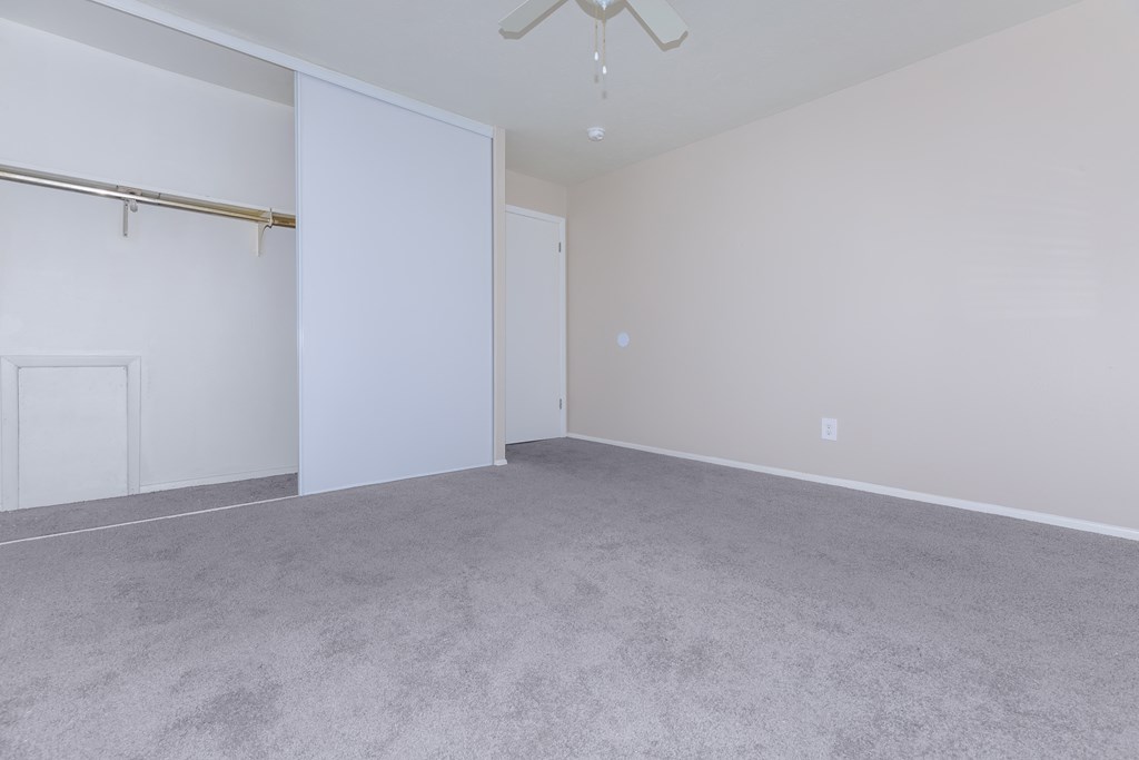 a bedroom with a closet and a ceiling fan