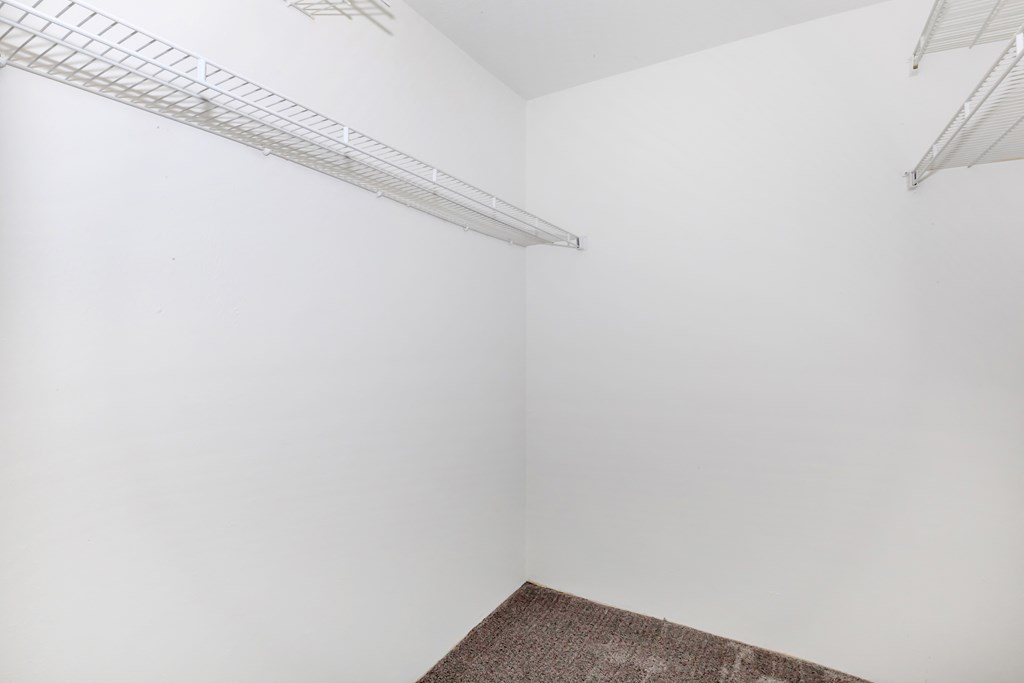 a small room with white walls and a white shelf on the wall