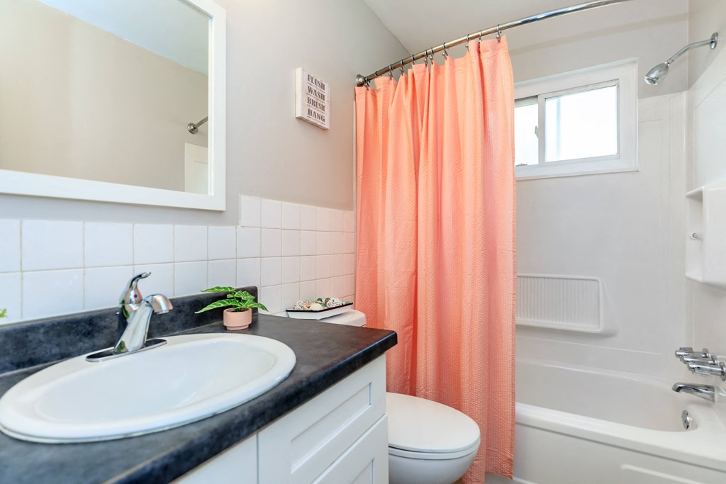 a bathroom with an orange shower curtain