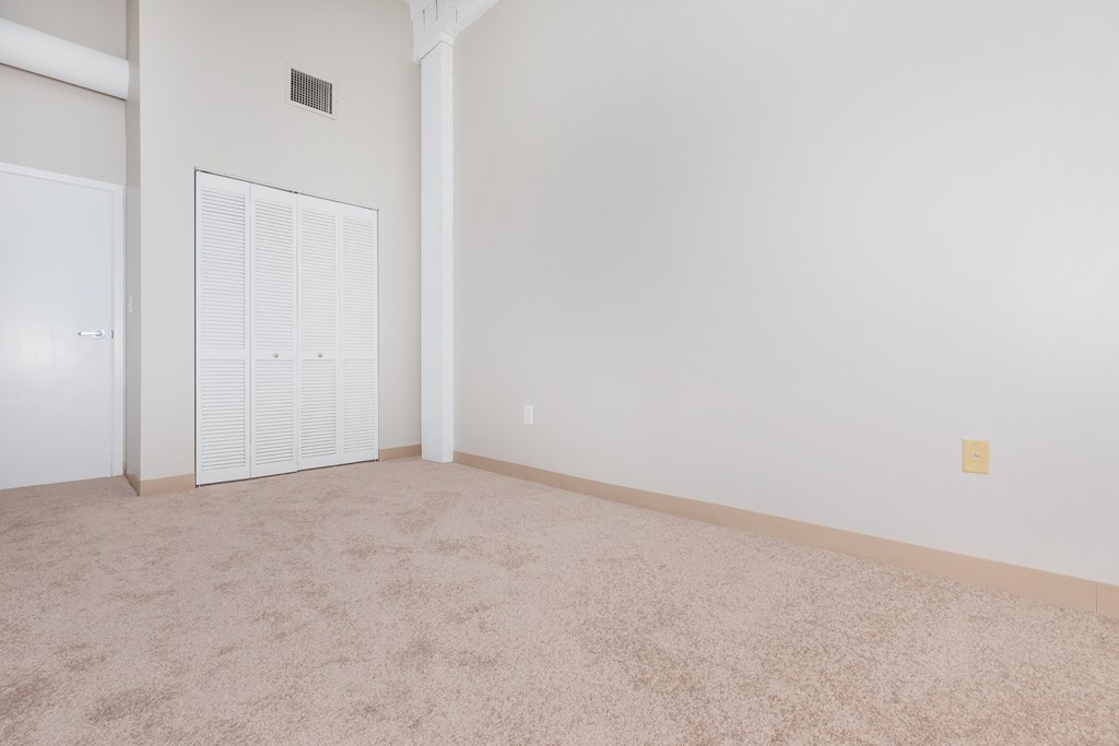an empty living room with a door to a closet